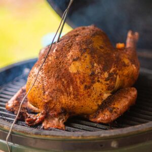 Best smoked whole turkey recipe with cajun butter injection and a cajun rub. Served on a cutting board.