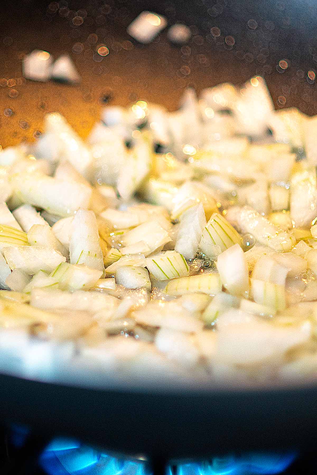 Onions being sautéd in a wok.