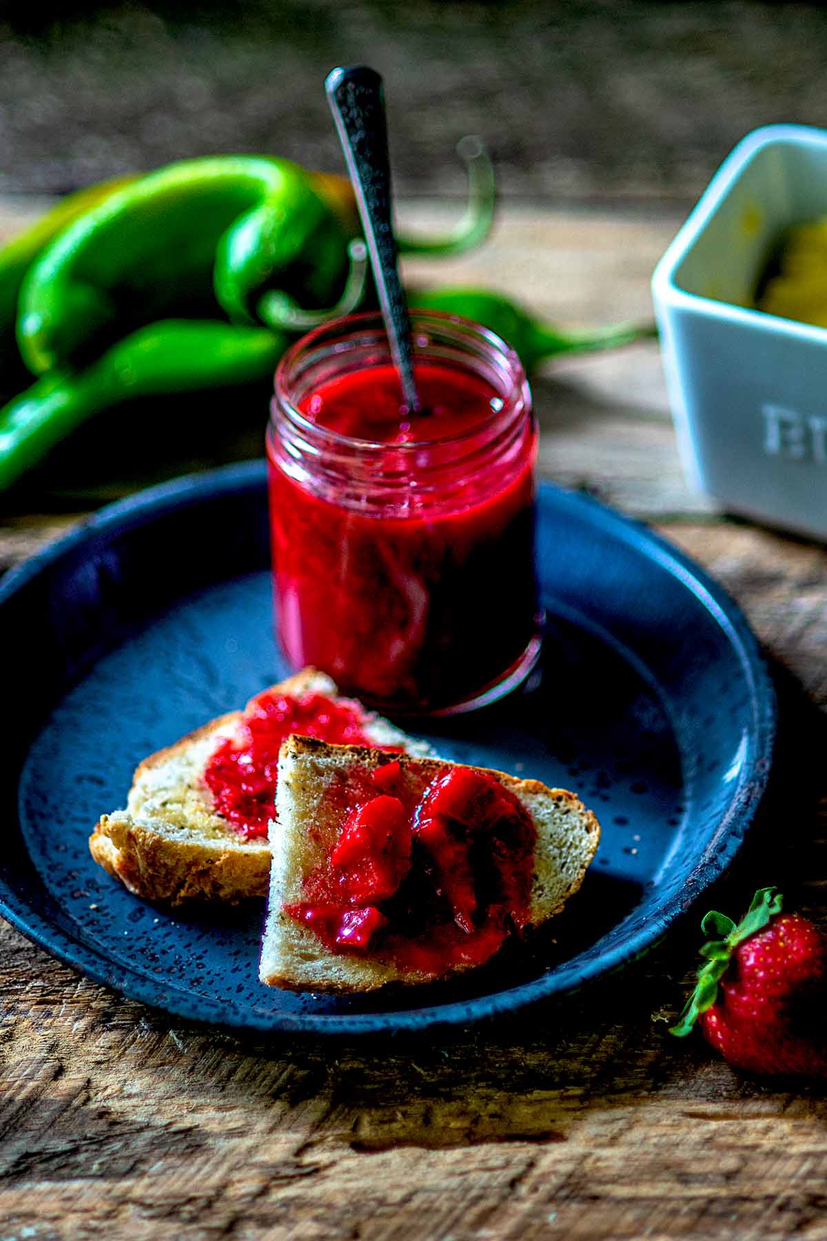 Strawberry Rhubarb Hatch Green Chile Reduction served on toast with a jar and spreader.
