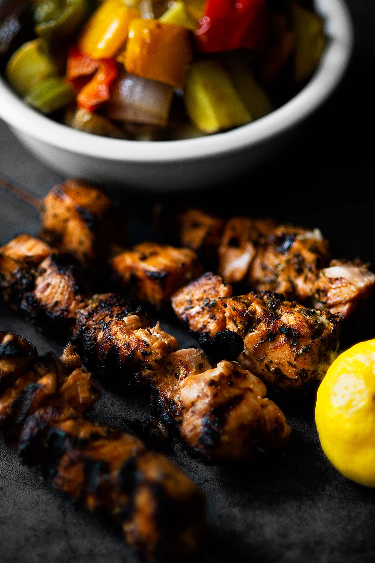 Salmon skewers served with a lemon on the side. 