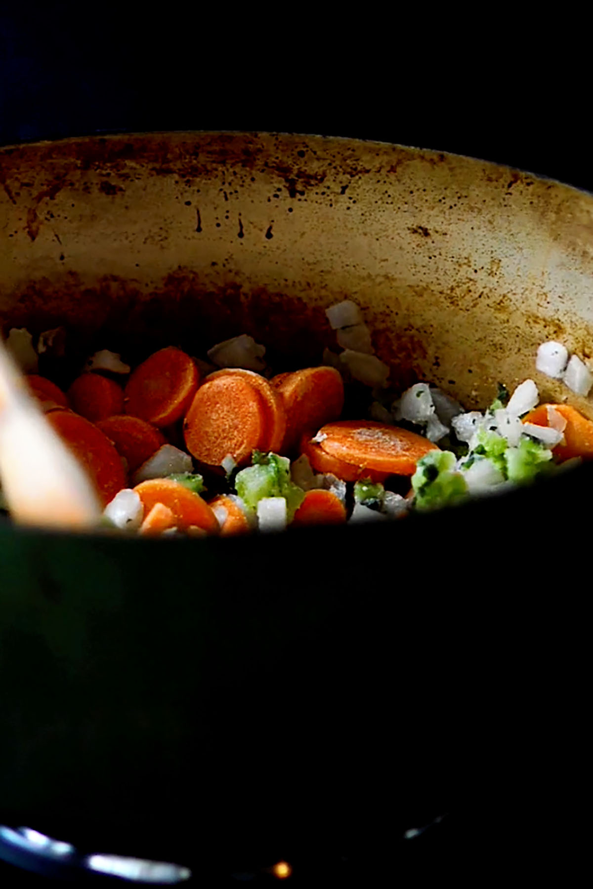 Freshly sliced vegetables sautéing in an enameled cast iron dutch oven.