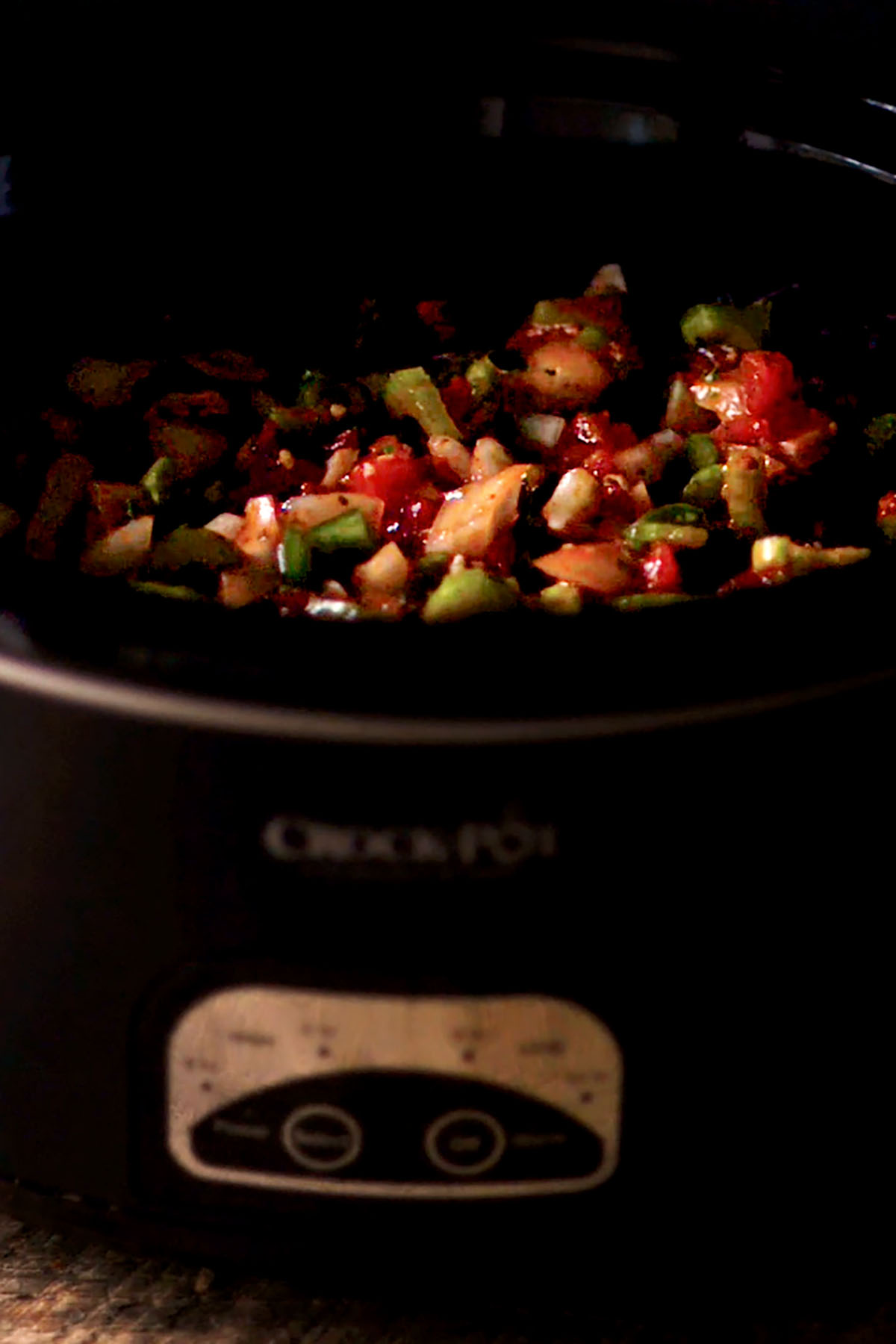Diced vegetables added to a slow cooker.