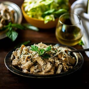 Rigatoni D with blackened Chicken and a creamy wine based mushroom sauce served in a rustic platter and garnished with Italian parsley.