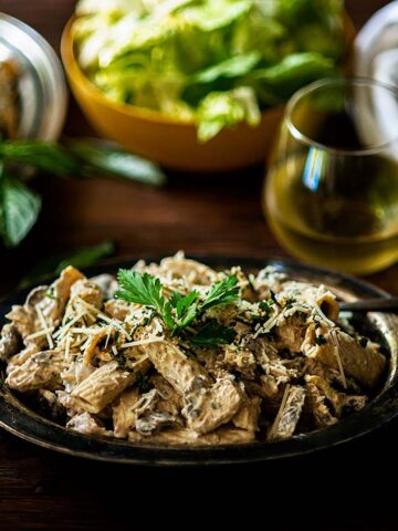 Rigatoni D with blackened Chicken and a creamy wine based mushroom sauce served in a rustic platter and garnished with Italian parsley.
