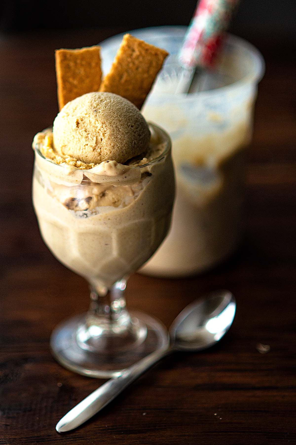 Homemade bananas foster ice cream served in glass serving dishes and garnished with graham crackers.
