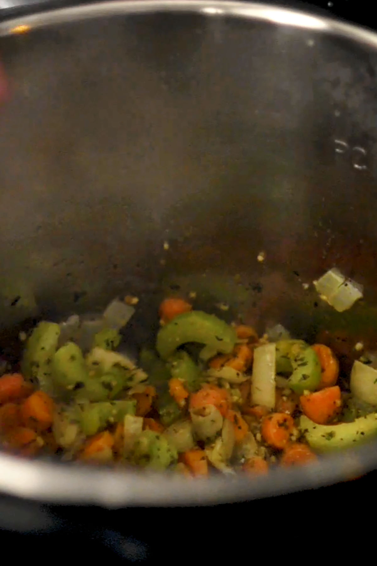 Seasoning added to sautéd vegetables in an Instant Pot.