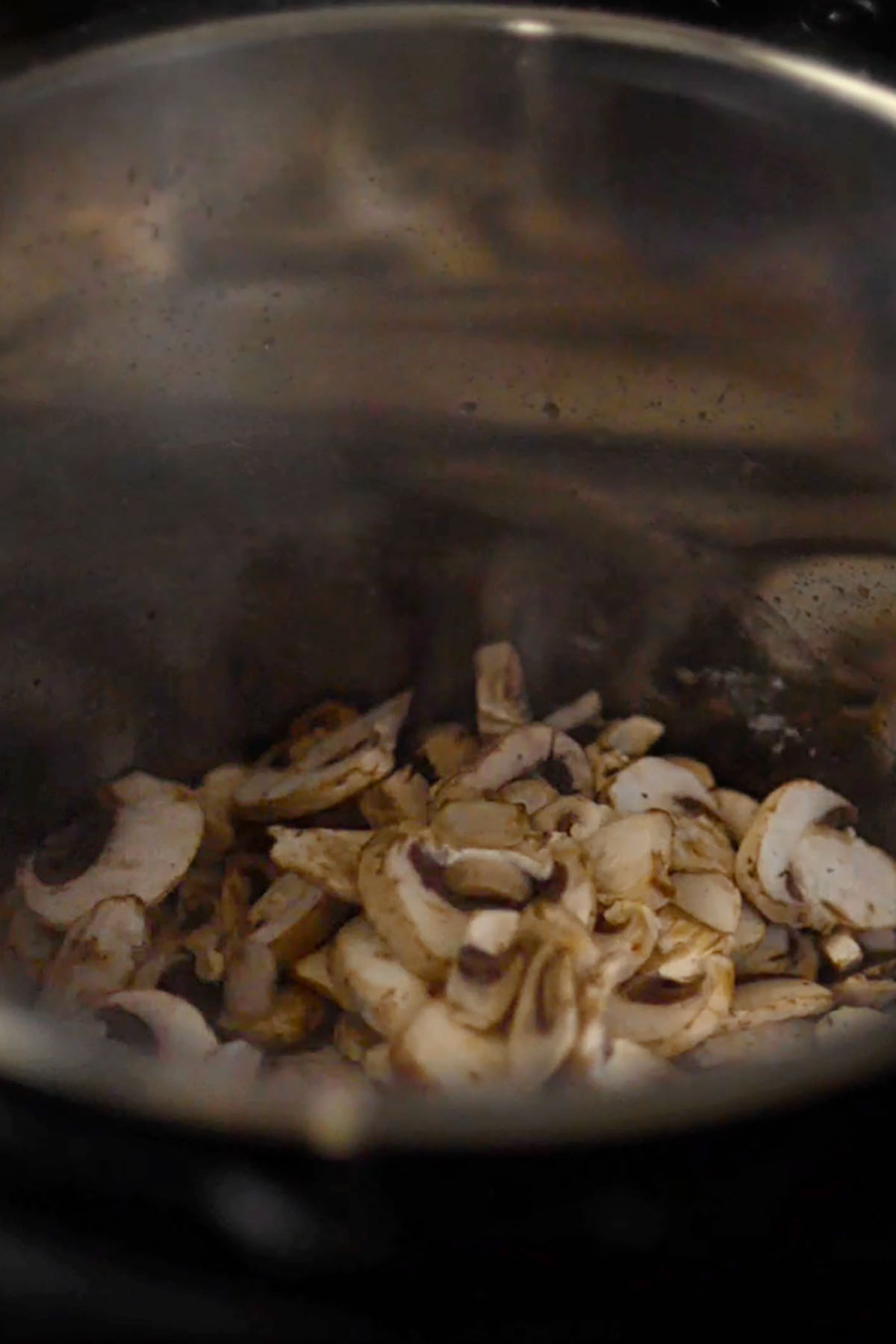 Mushrooms being sautéd in a pressure cooker.