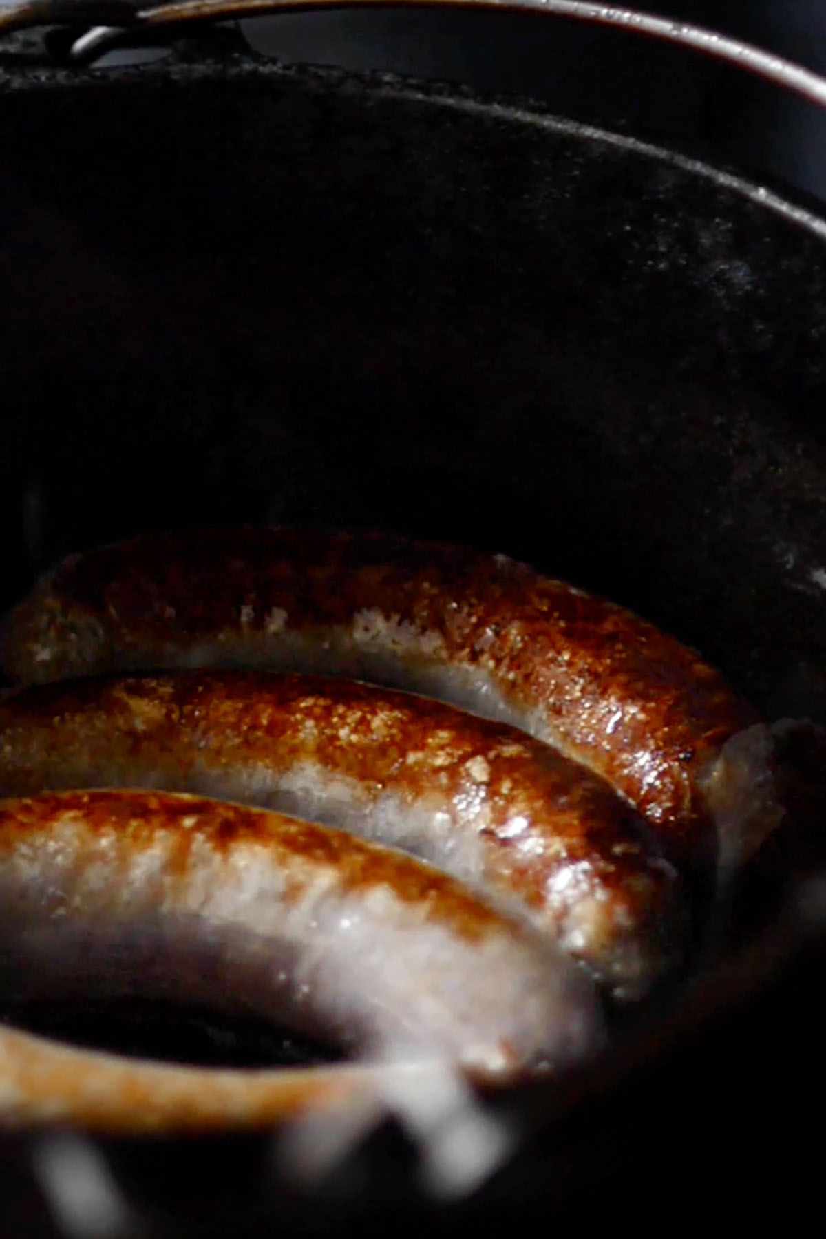 Bratwurst browned in a cast iron dutch oven.