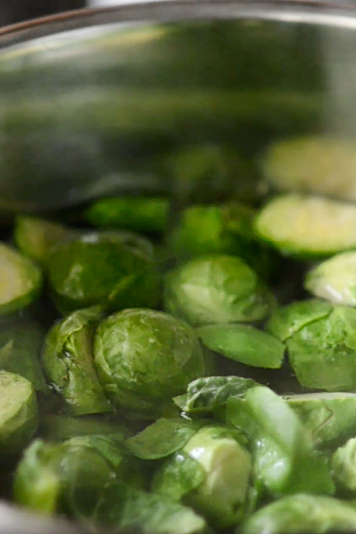 Brussels sprouts being blanched in a pot of water.