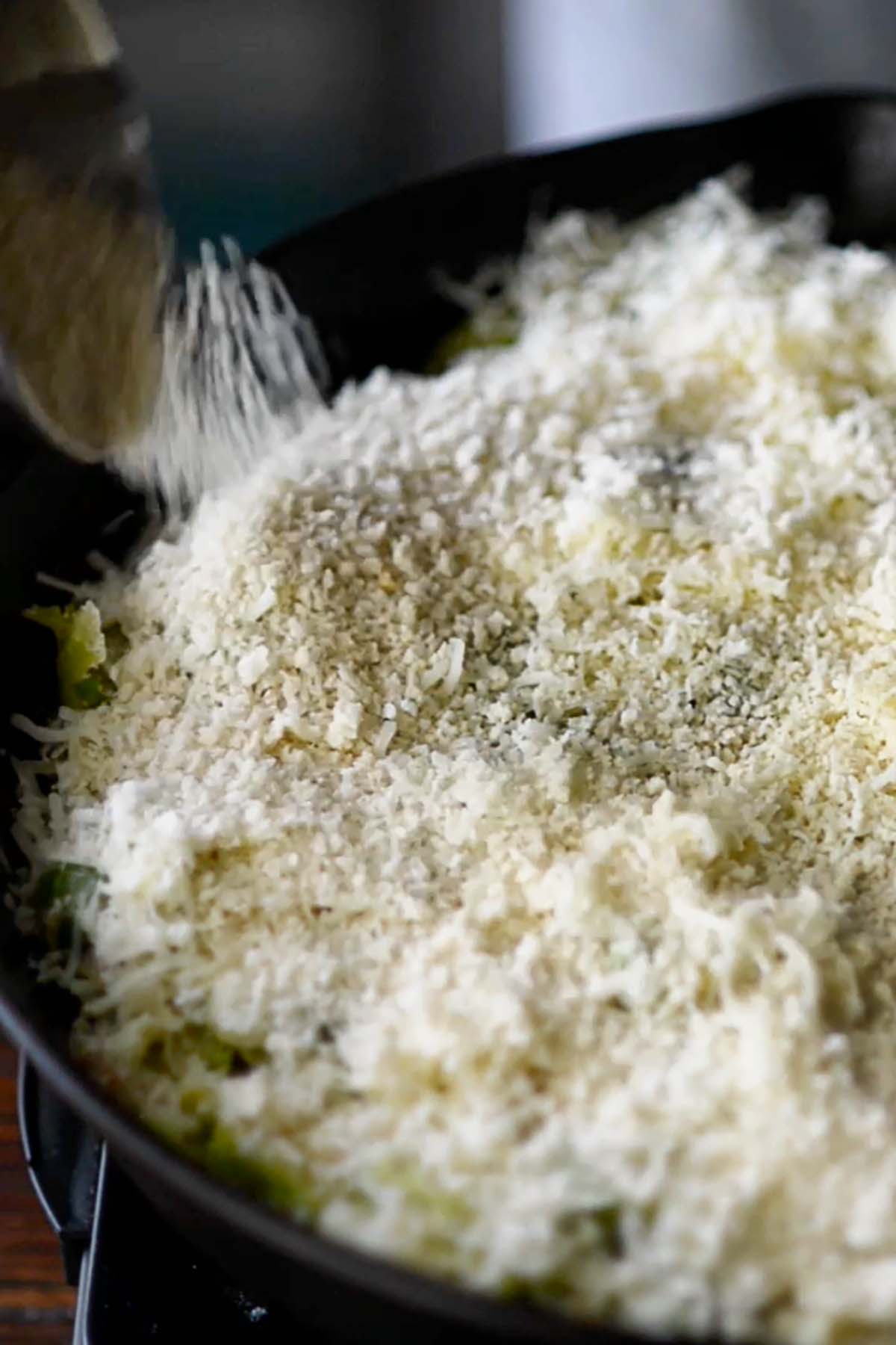 Panko bread crumbs covering creamy Brussels Sprouts in a cast iron skillet.