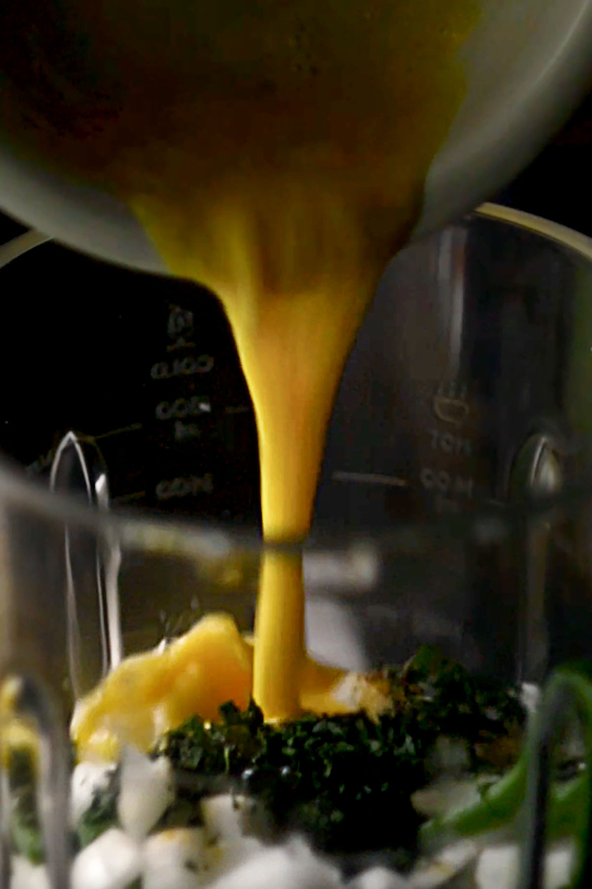 Egg being poured into a cooking blender.