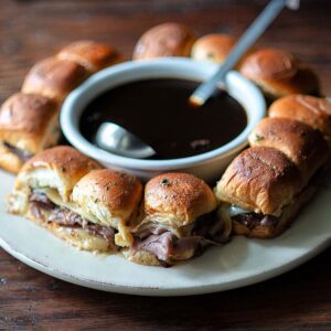 French Dip Sliders plated and served with a bowl of jus.