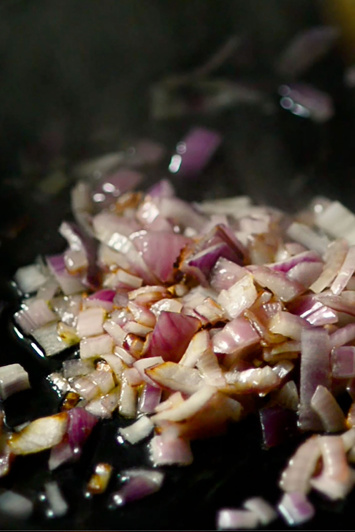 Red onions sautéing in butter in a cast iron skillet.