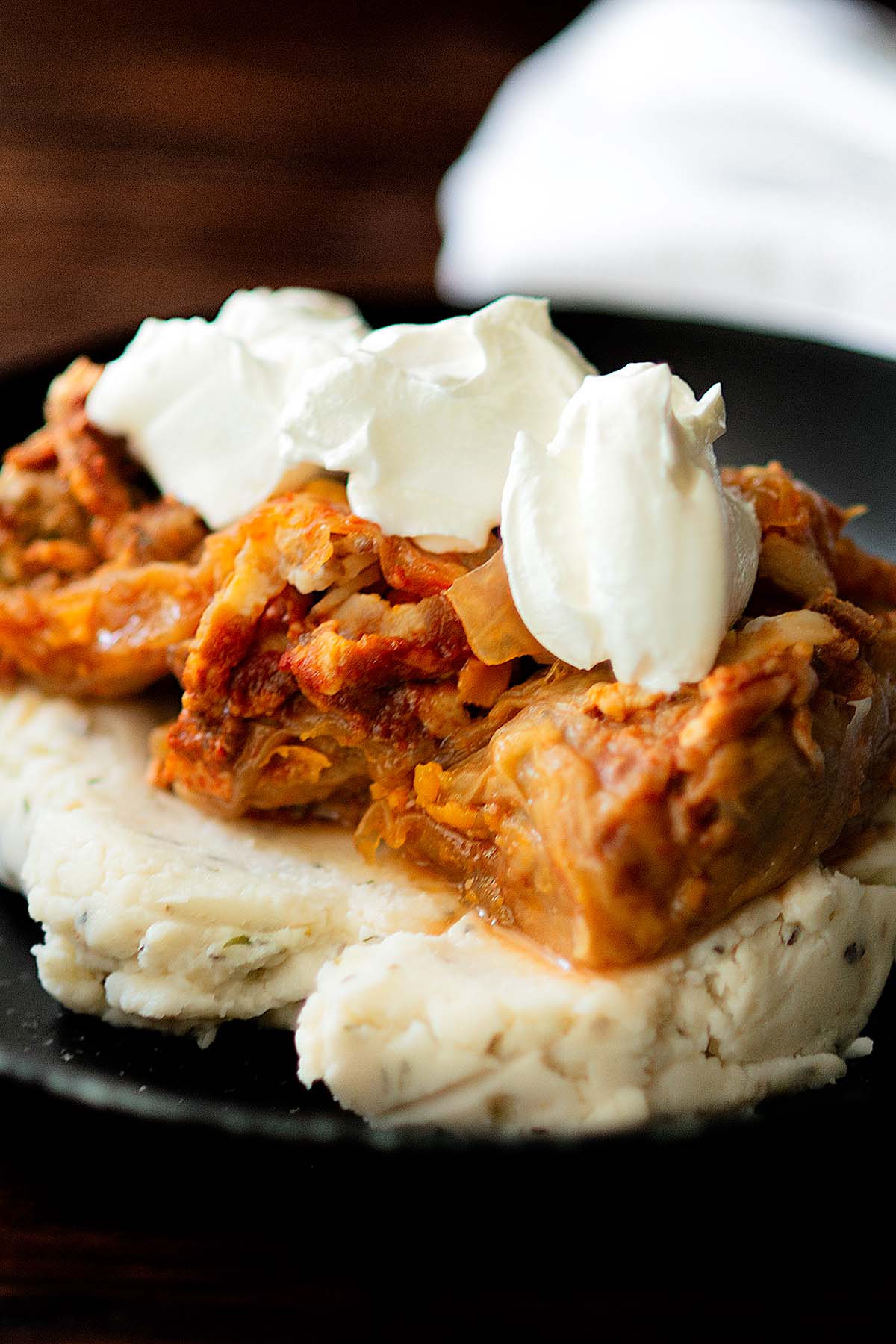 Romanian cabbage rolls served over mashed potatoes and topped with sour cream.