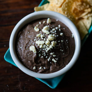 Black Bean Dip served with chips and garnished with Queso Fresco.