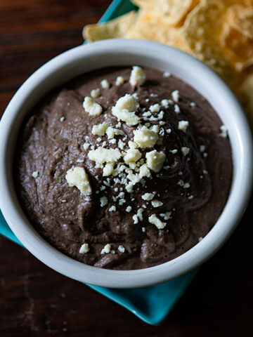 Black Bean Dip served with chips and garnished with Queso Fresco.