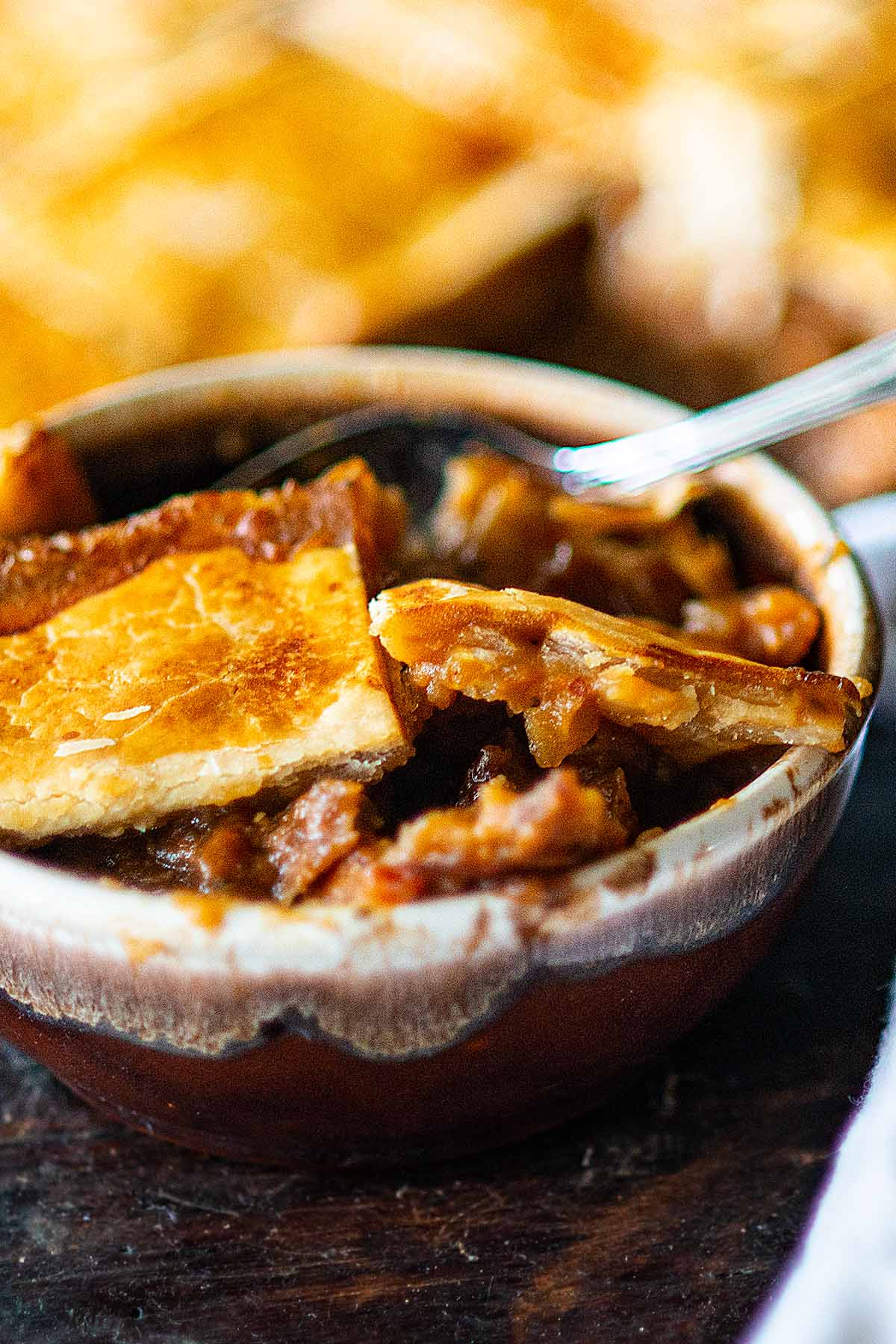 Irish beef stew pot pie served in a rustic brown bowl.