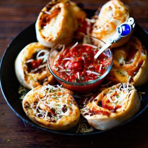 Meat Lover's Pizza Rolls served with an arrabbiata sauce and garnished with fresh parmesan.