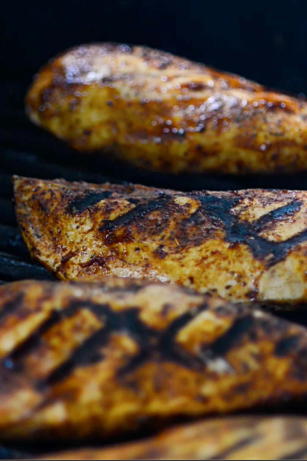 Chicken breasts on the grill with cross hatched grill marks.