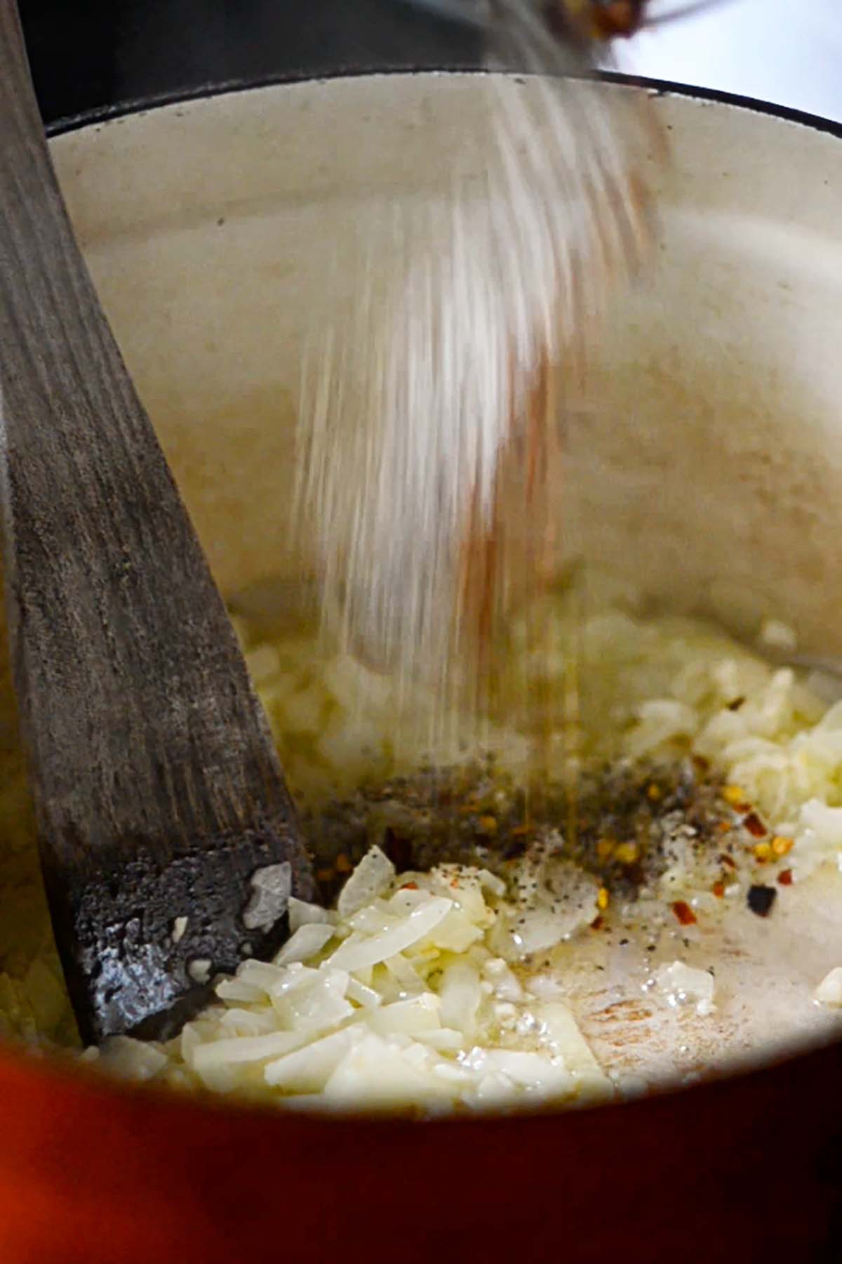 Herbs and spices are added to sautéd onions.