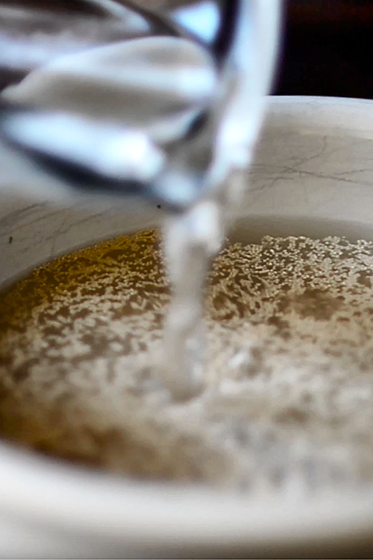 Water being poured into a bowl or yeast.