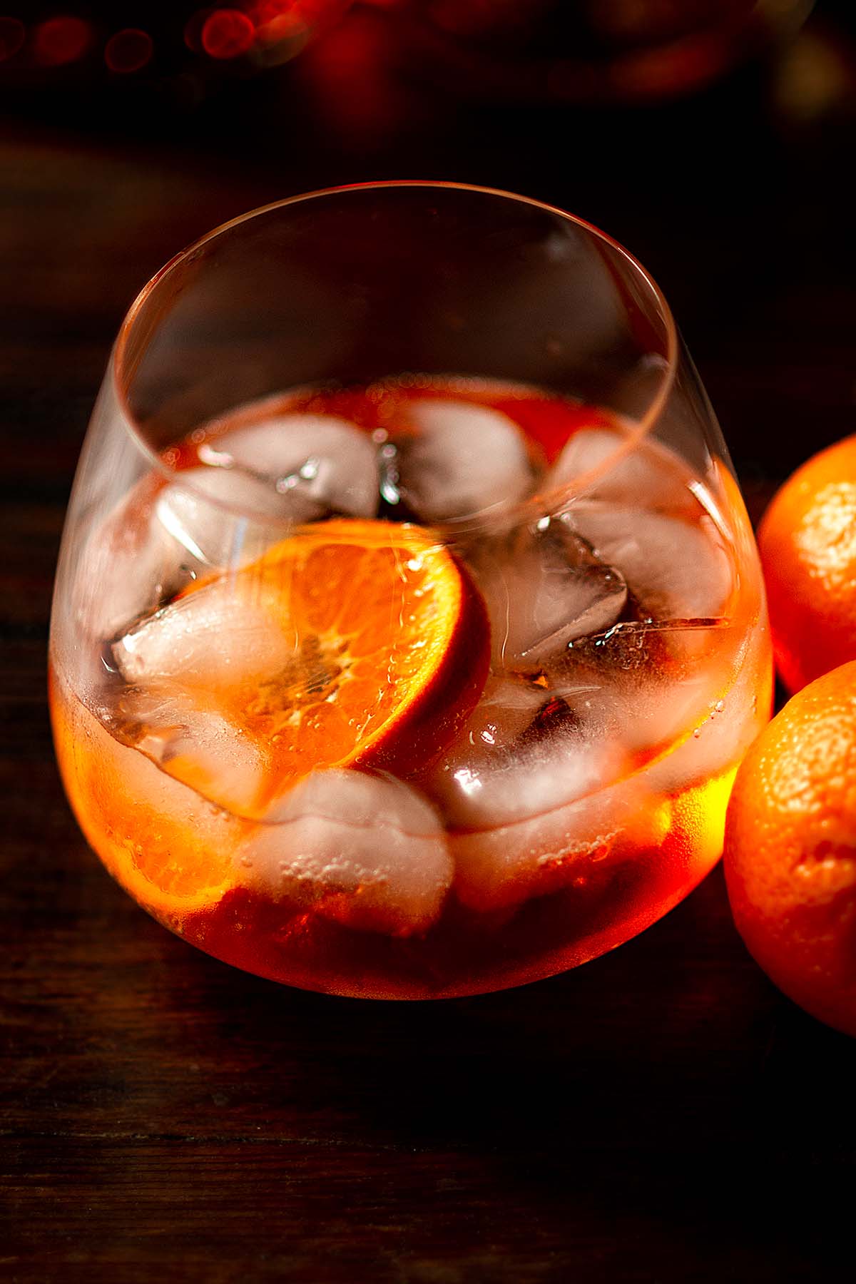 Slice of orange added to a wine glass of Aperol Spritz.