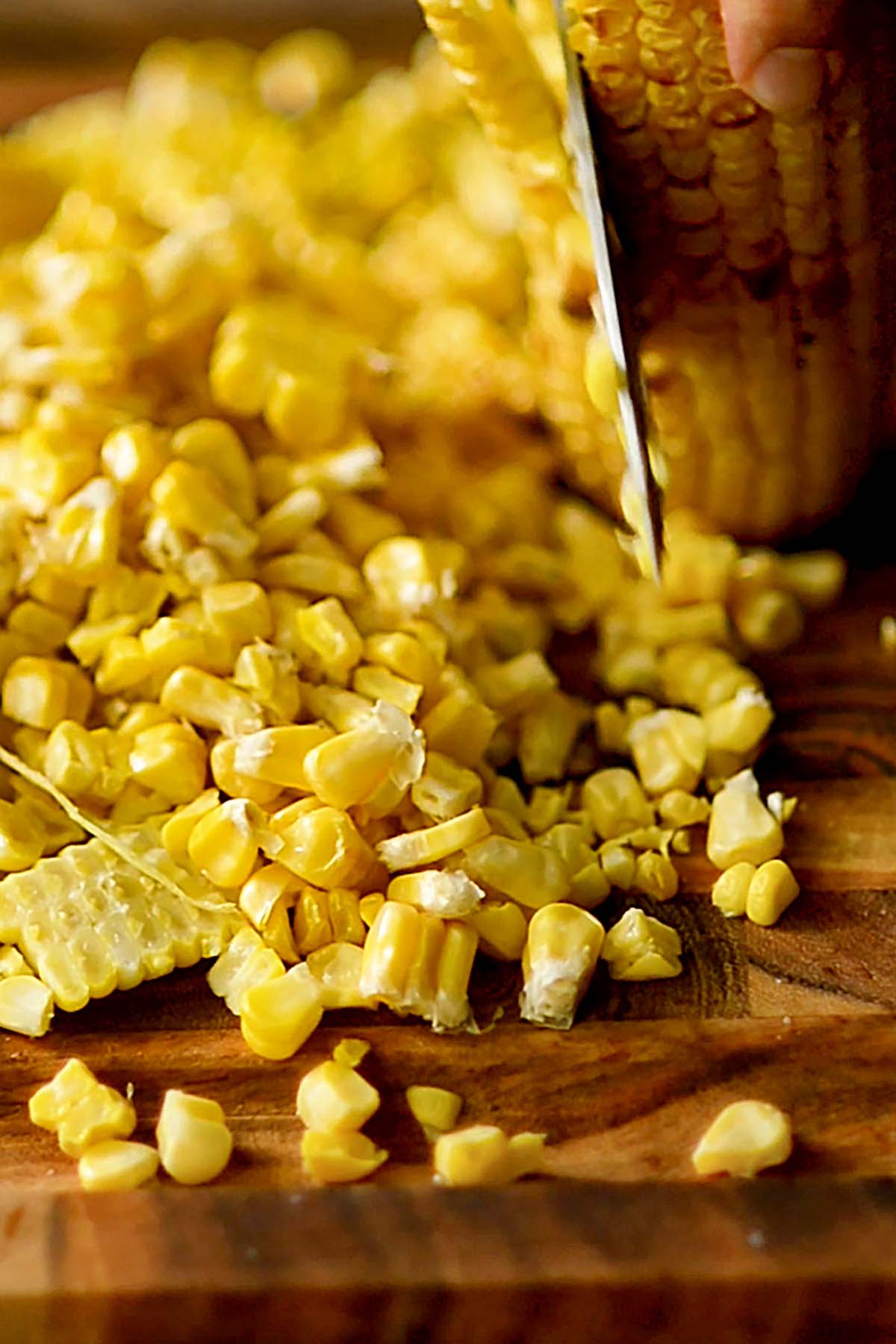 Roasted corn being sliced off the cob.
