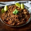 Barbacoa served with lime wedges and toped with Cilantro.