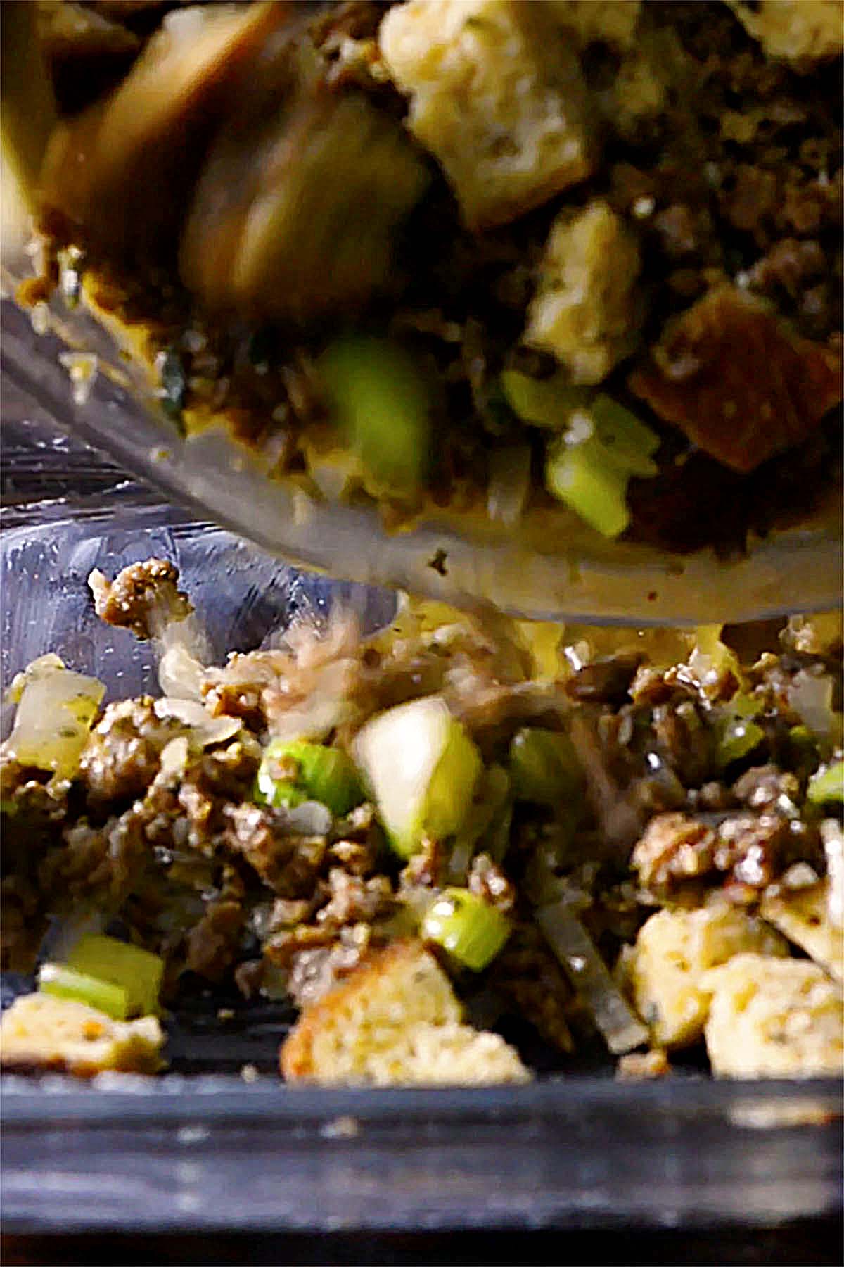 Italian Sausage Stuffing Mix being added to a 9x13 baking dish.