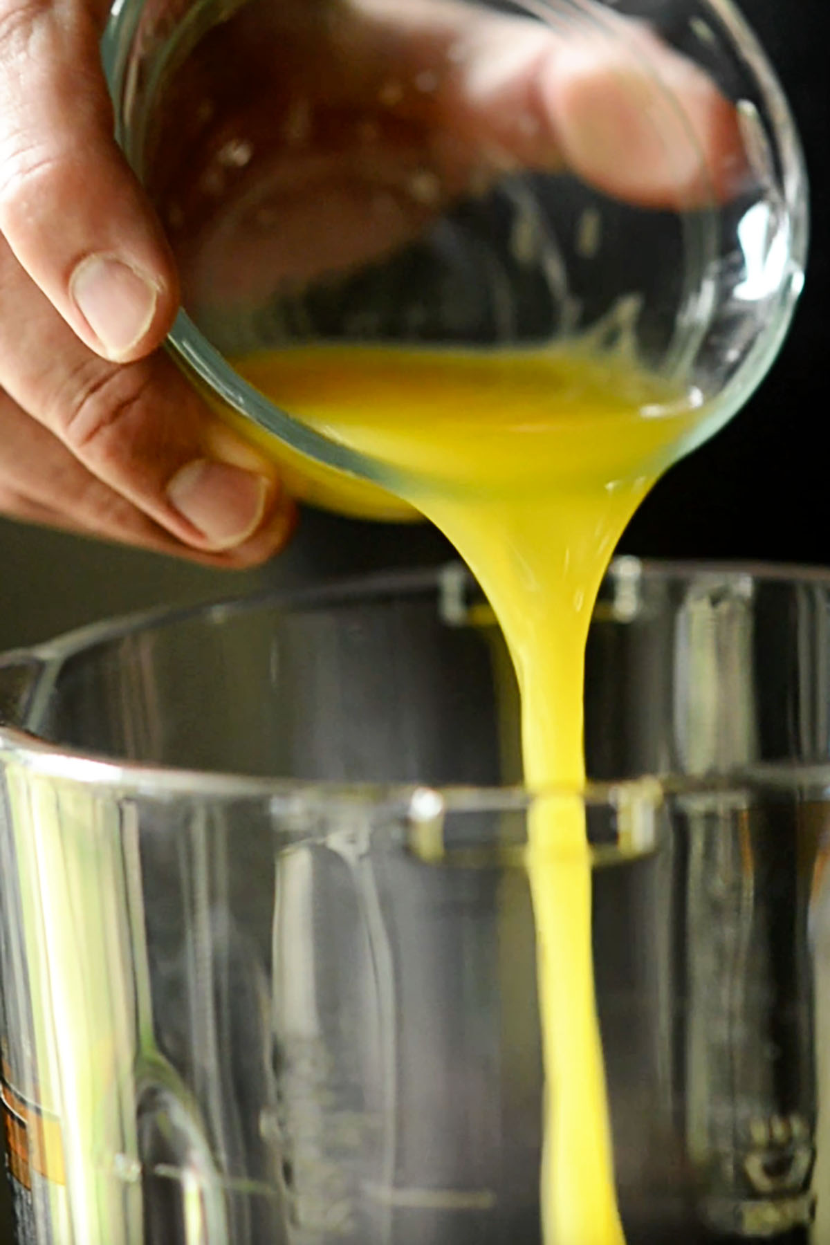 Orange juice being added to a blender.