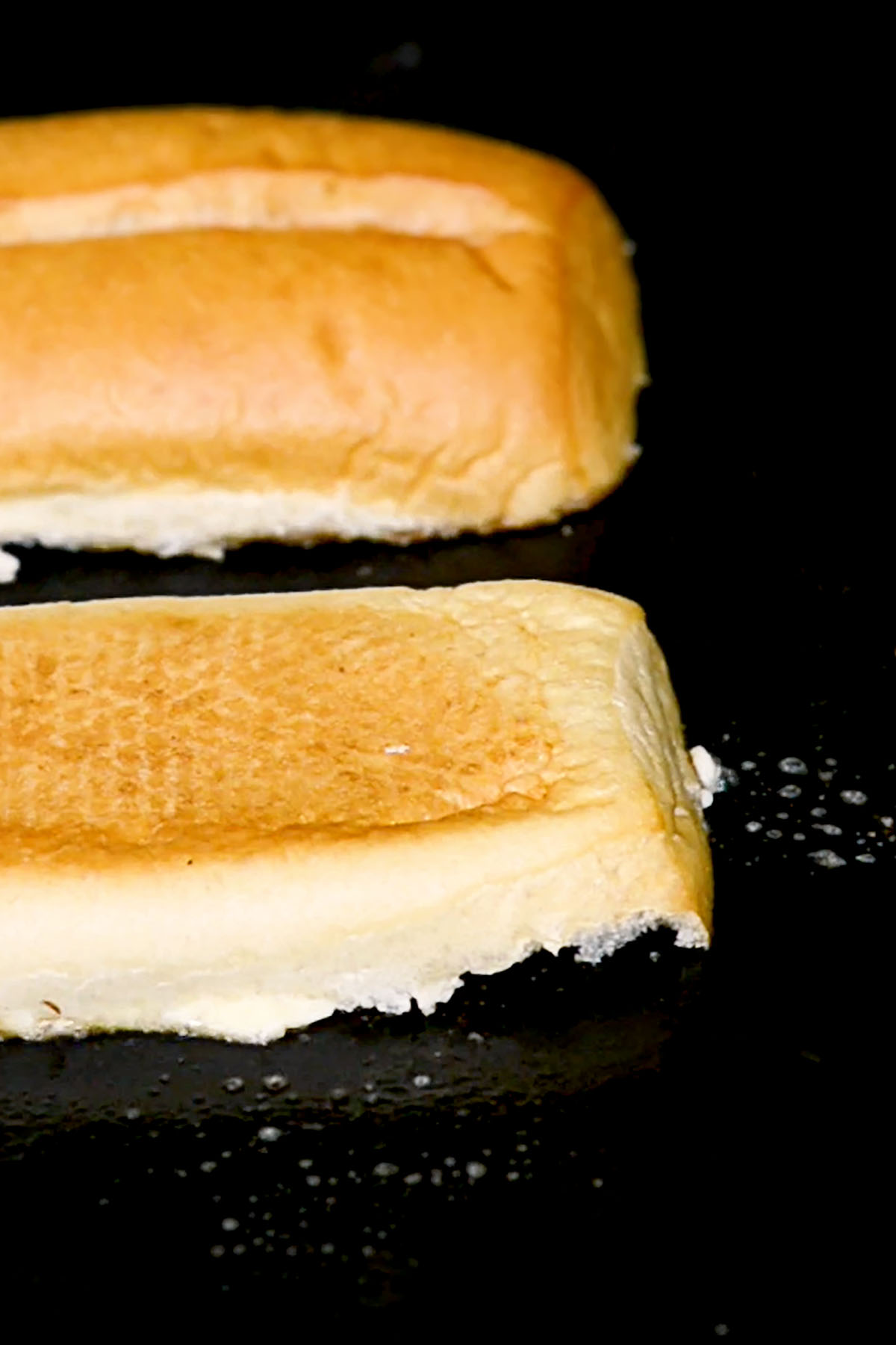 A hoagie bun toasting on a Blackstone griddle.