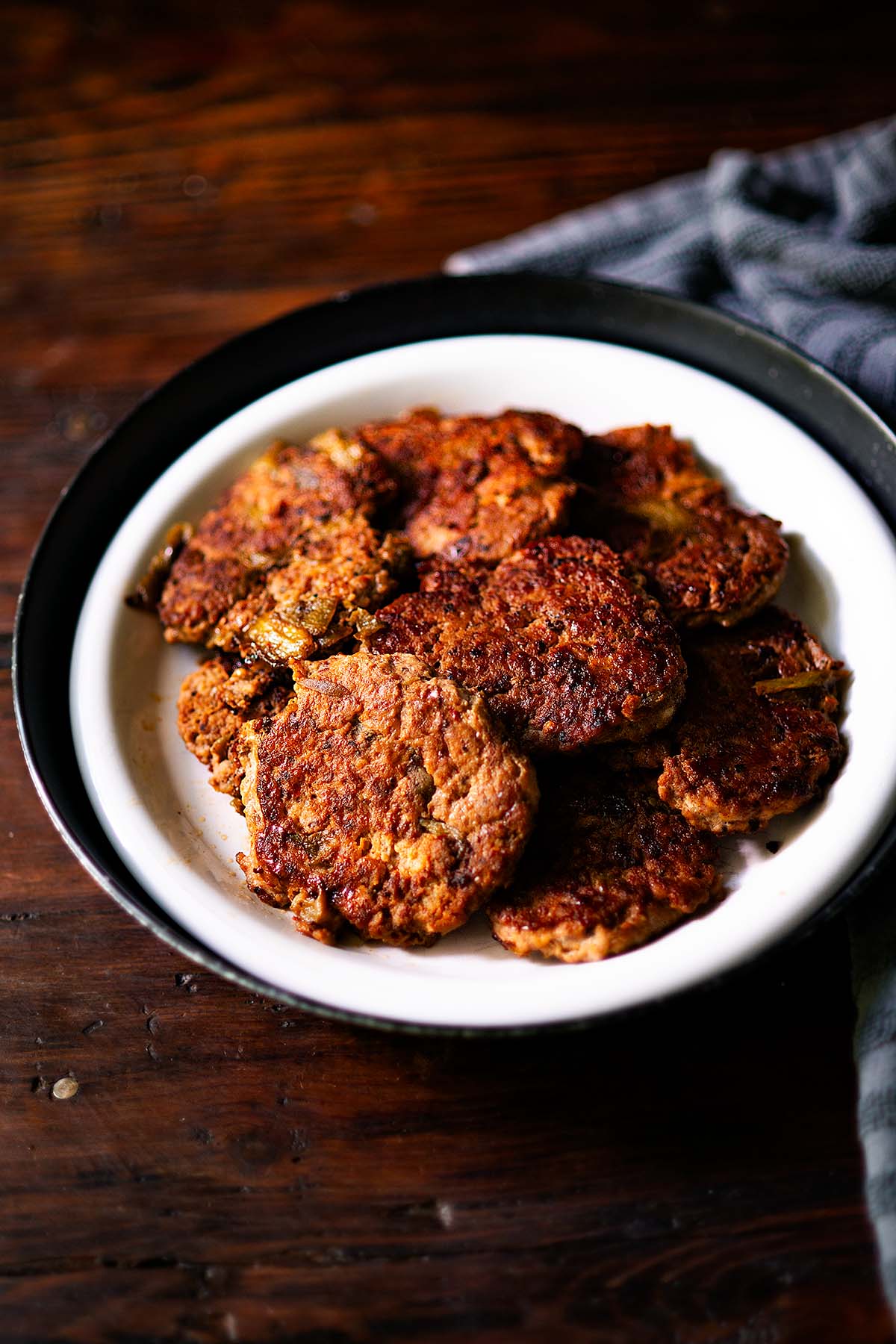 Chicken Breakfast Sausage Patties piled on a plate and served family style.