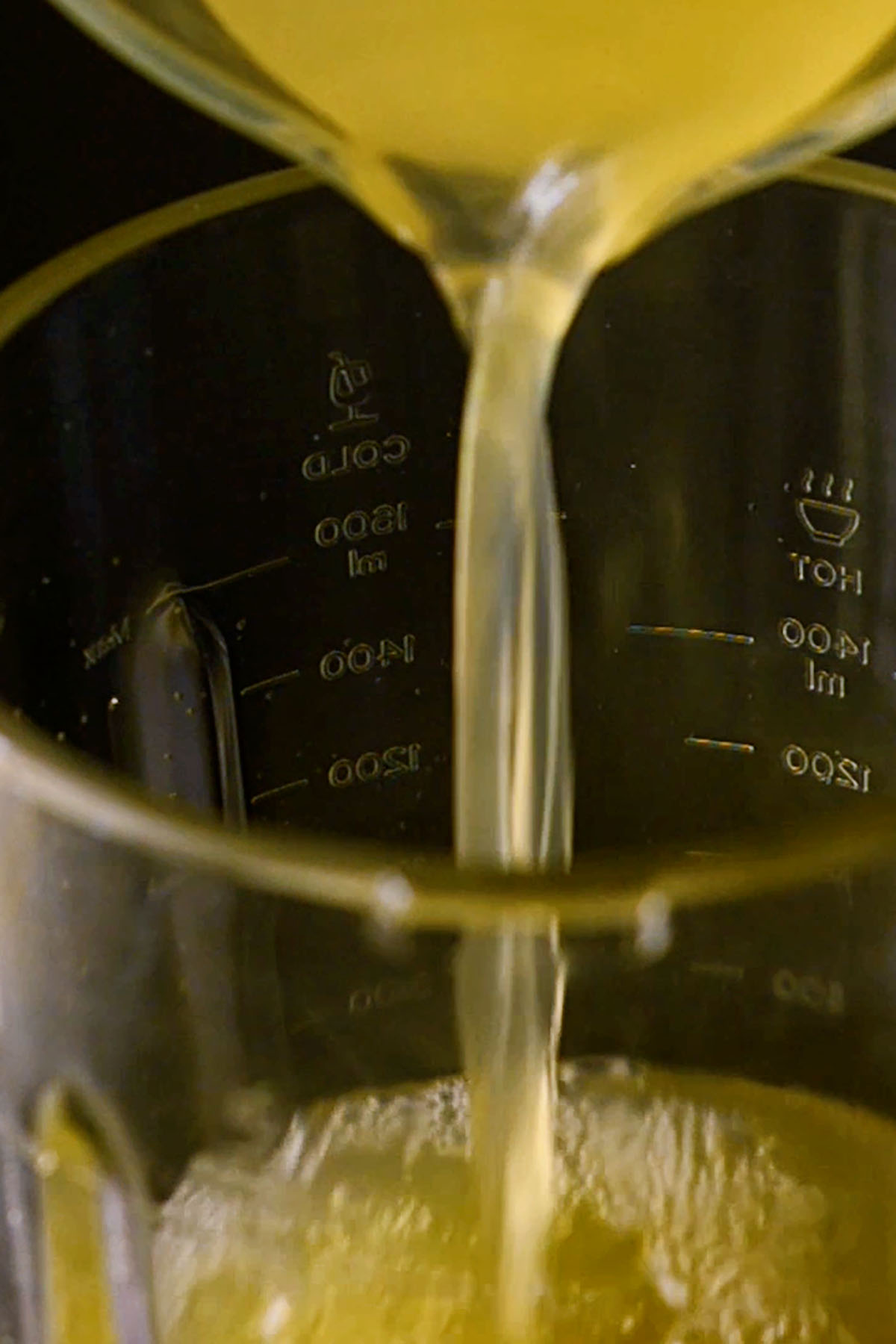 Chicken stock being poured into a blender.