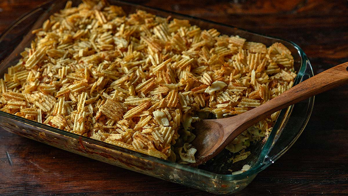 Old Fashioned Tuna Noodle Casserole Served family style in a casserole dish with a large wooden serving spoon.