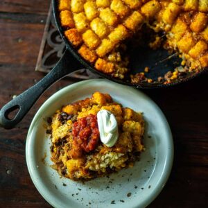 Taco Tater Tot Casserole Served topped with salsa and sour cream then sprinkled with dried Mexican oregano.