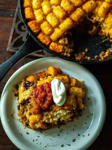 Taco Tater Tot Casserole Served topped with salsa and sour cream then sprinkled with dried Mexican oregano.