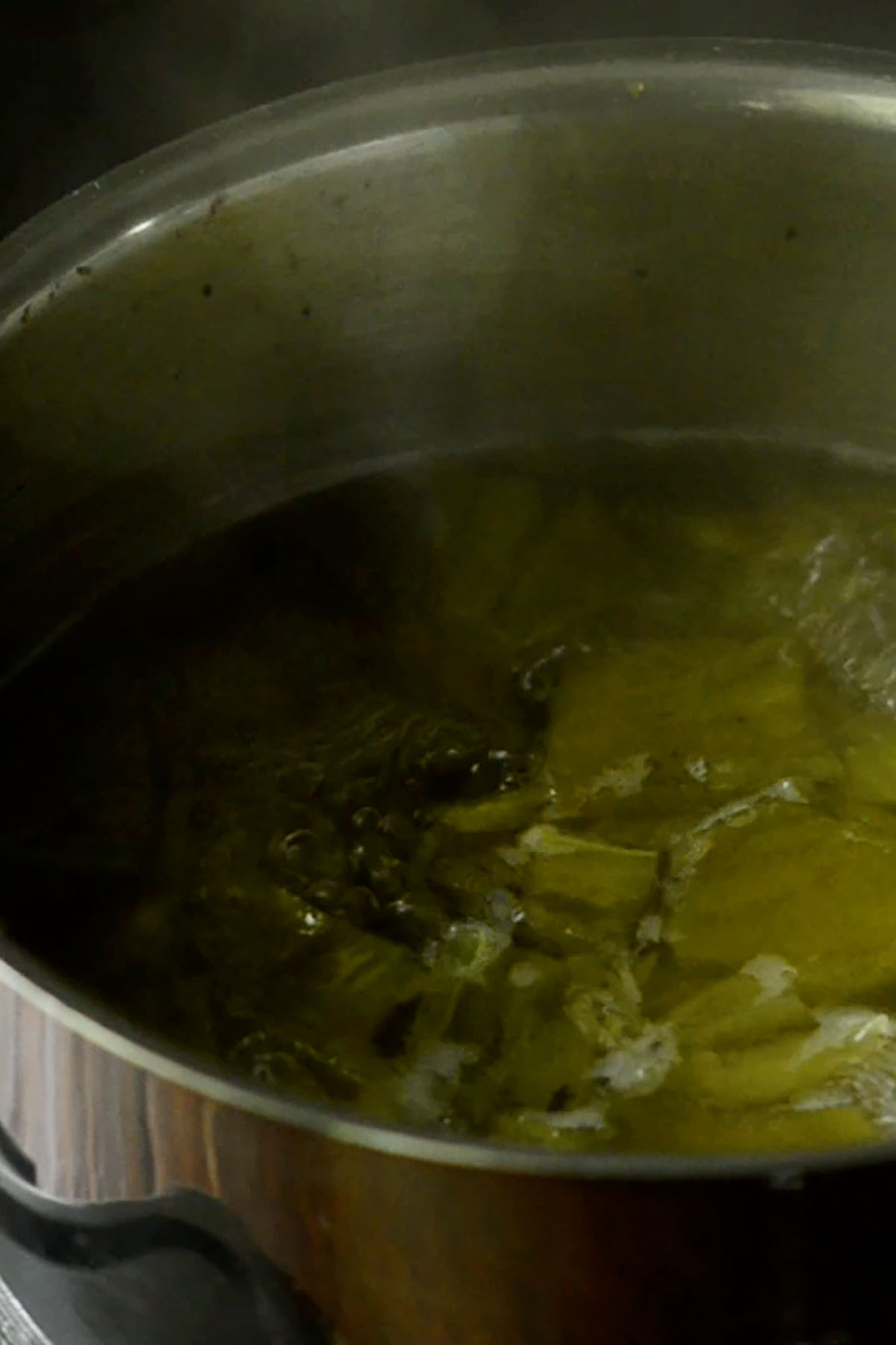 Hatch chiles boiling in a pot of water.