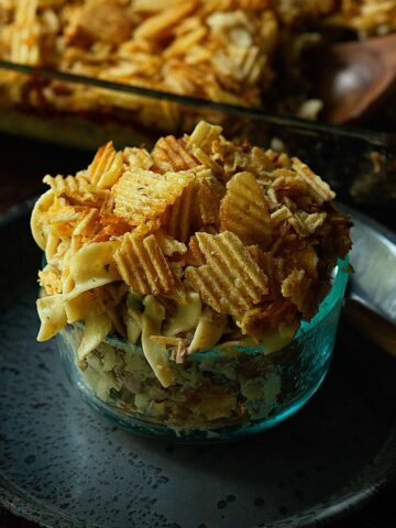 Old Fashioned Tuna Noodle Casserole served family style form a casserole dish topped with extra potato chips.