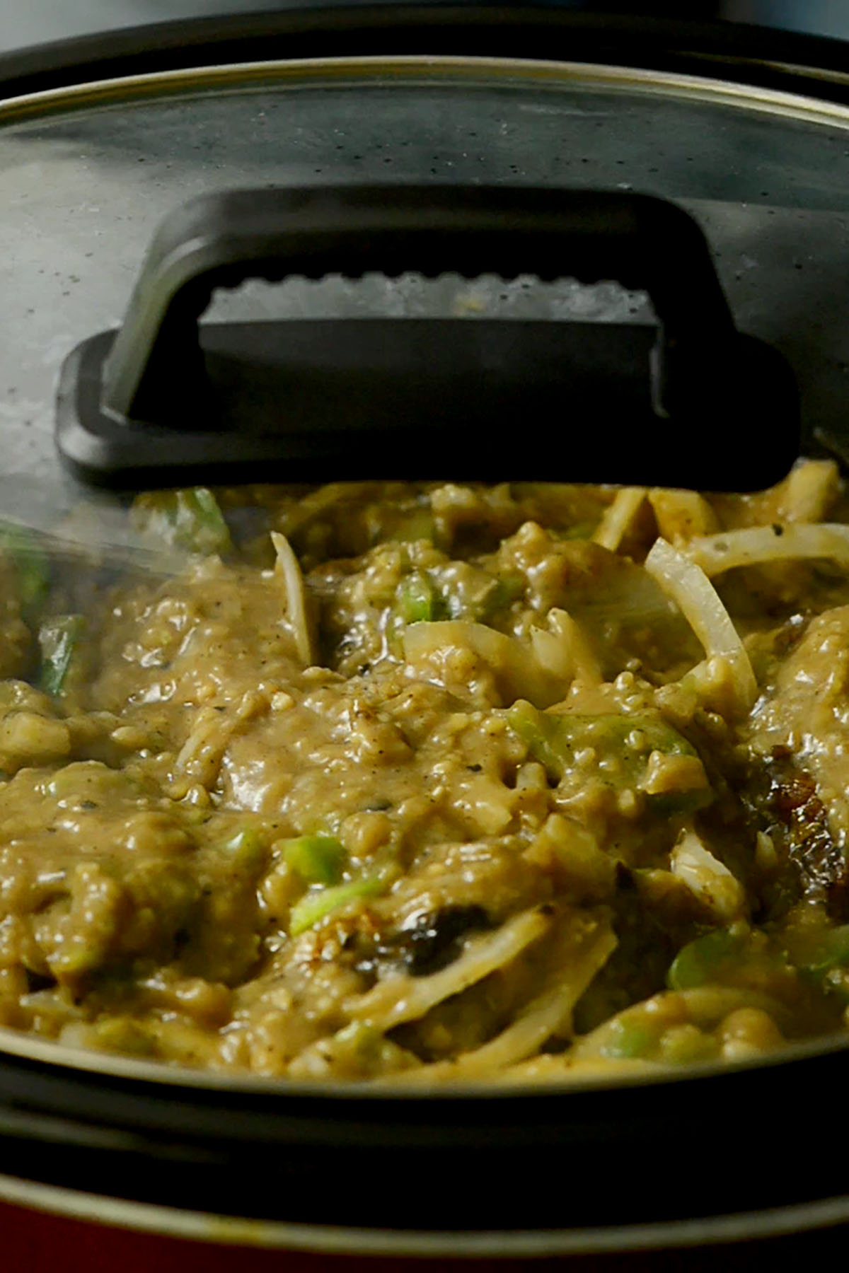 Souther oxtails smothered in a roux and vegetables in a slow cooker with the lid on.