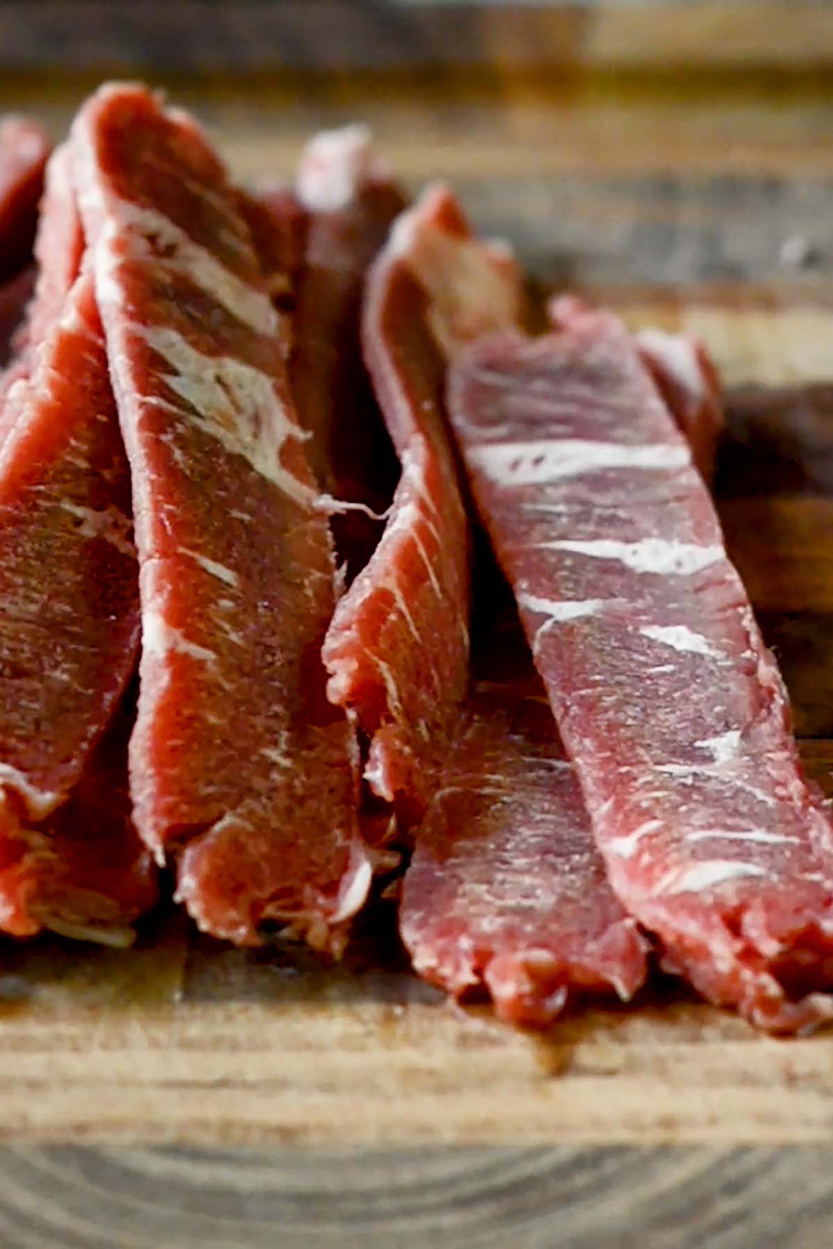 Thin slices of top sirloin steak on a butchers block.