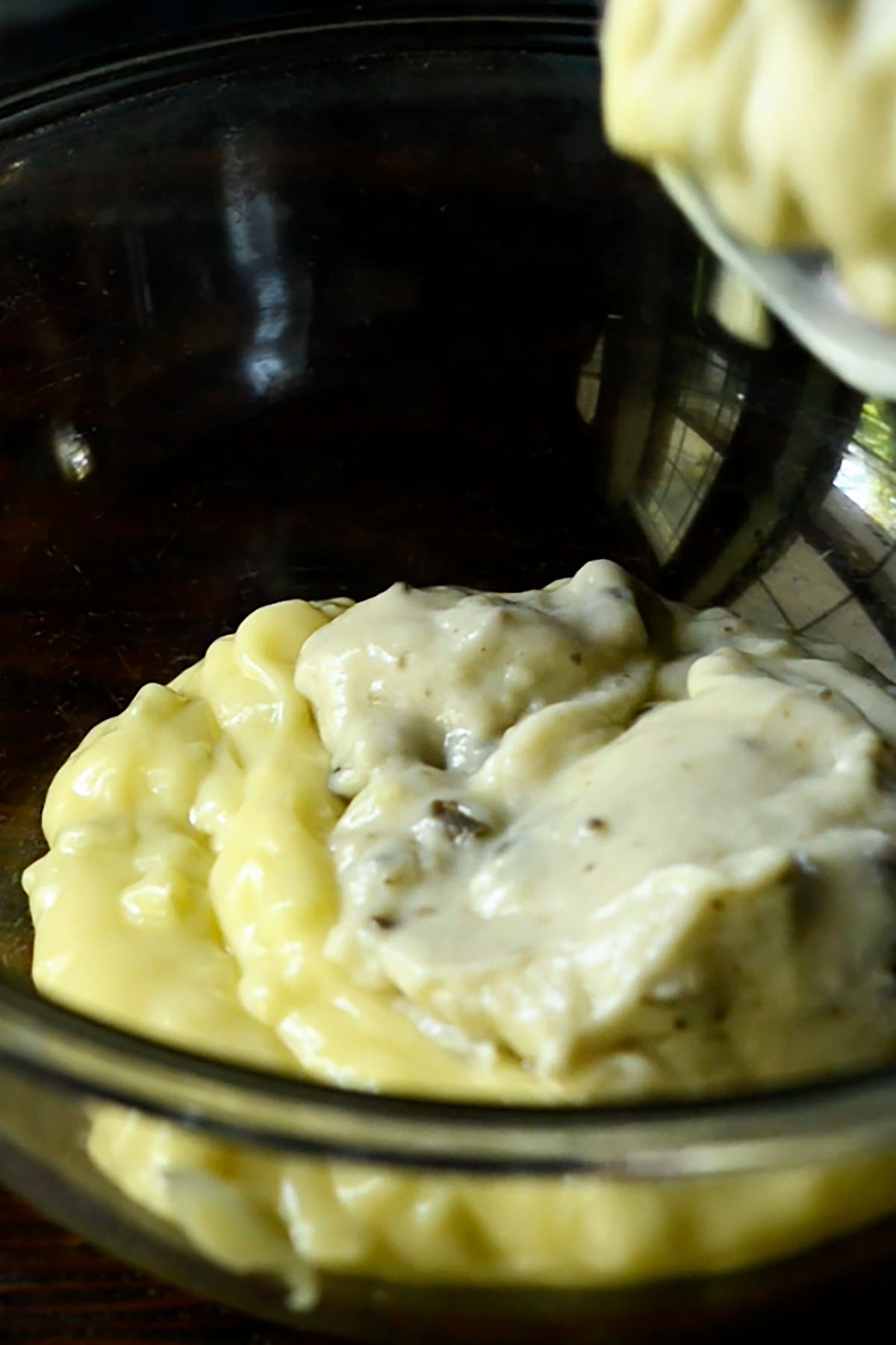 Cream of Mushroom and Cream of Celery Soup being poured into a glass mixing bowl.