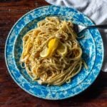 Crab Pasta served on a plate and garnished with a lemon wedge.