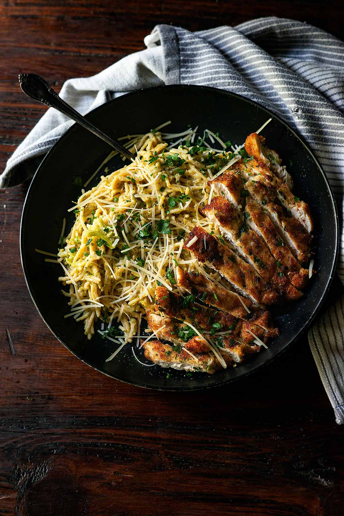 Cheddar Broccoli Pasta served on a deep dish plate with fried Italian-Style chicken cutlets.