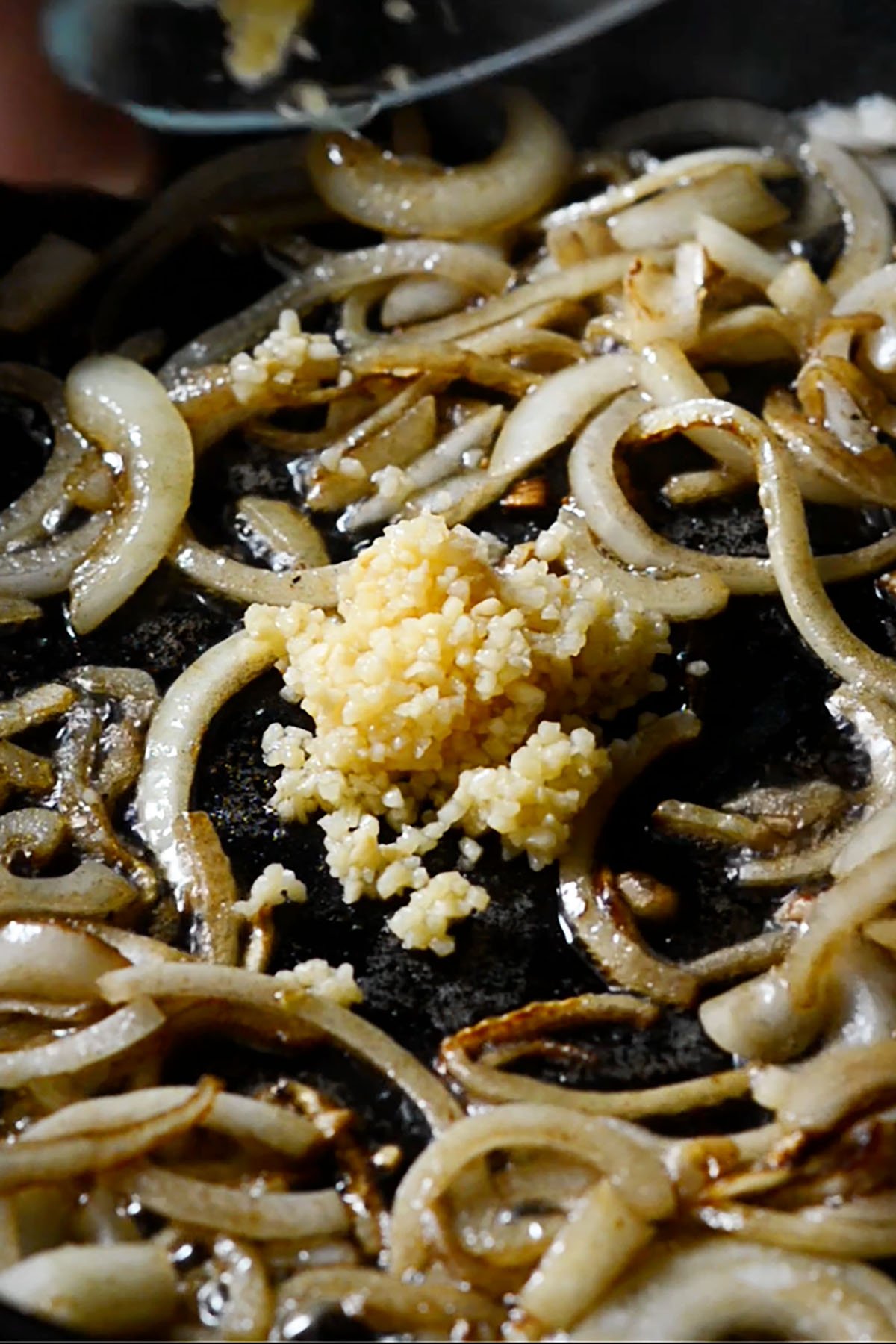 Onions and Garlic sautéing in a cast iron skillet.