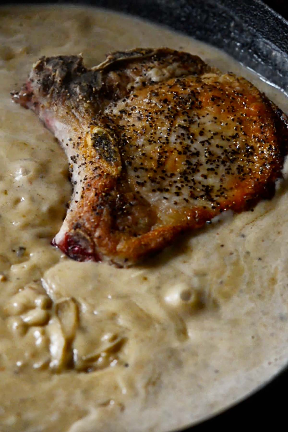 Seared pork chop smothered in a thick and creamy brown gravy.