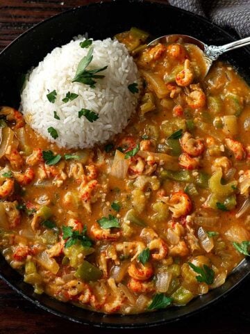 Crawfish étouffée served hot with white rice in a deep dish.