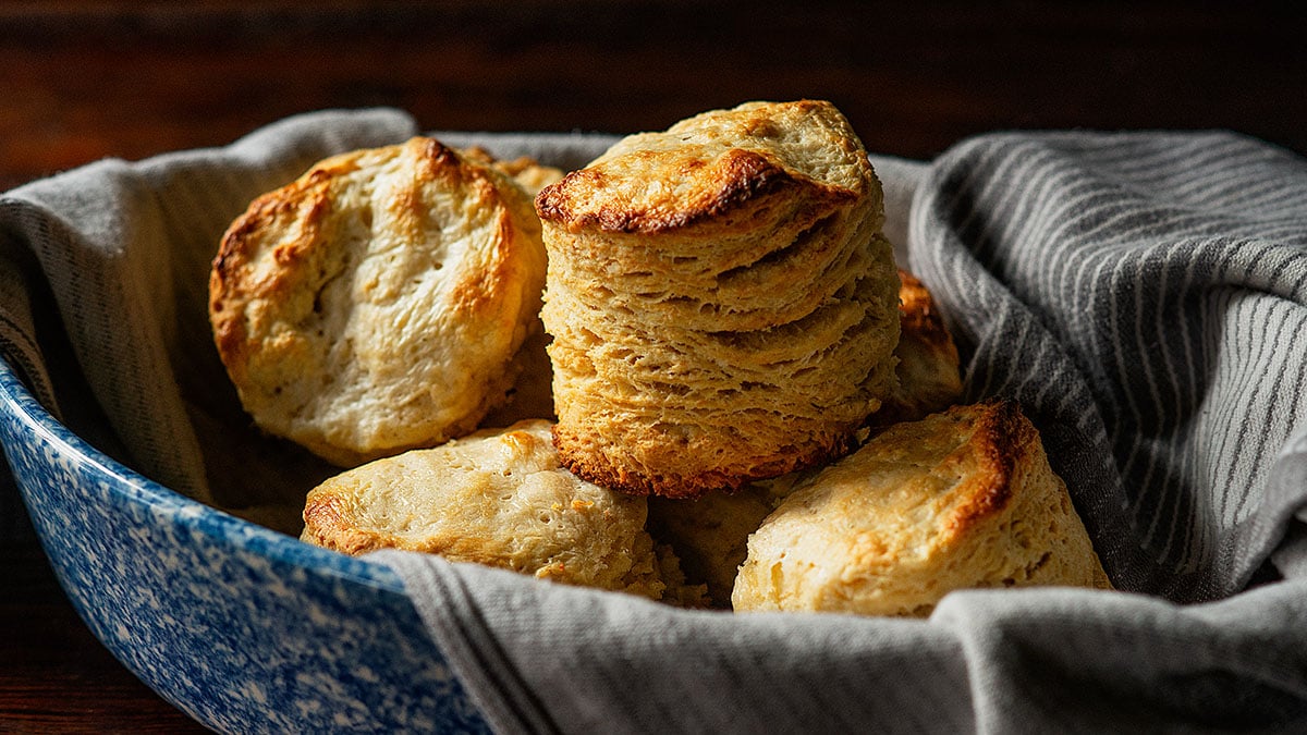 Freshly baked Southern Buttermilk Biscuits in a dish lined with a tea-towel.