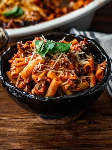 Baked Siti with Meat Sauce served and garnished with shredded mozzarella and Italian parsley.