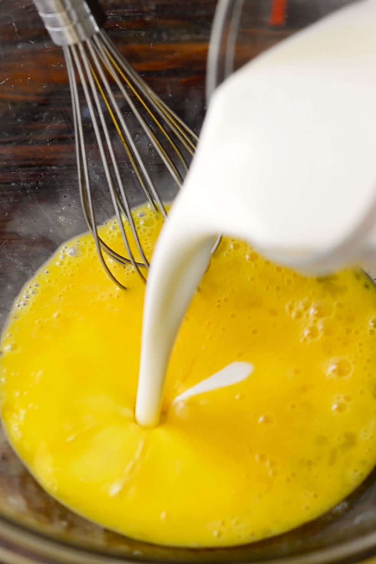 Buttermilk being poured into whisked eggs for fried okra batter,