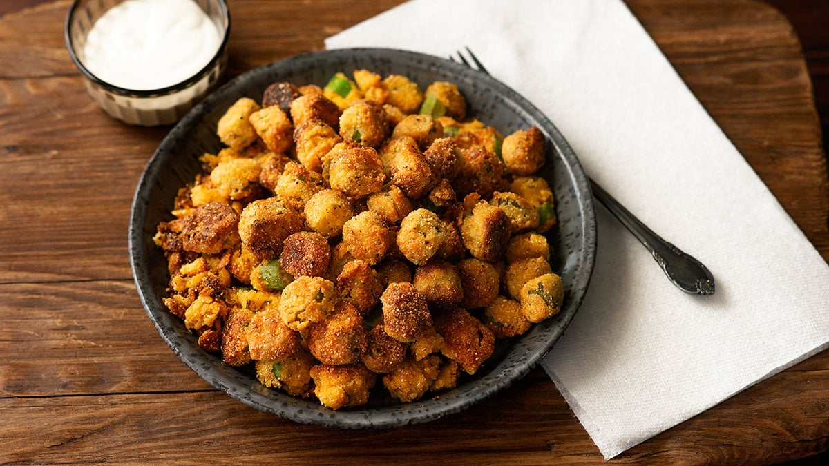 Skillet fried okra served with a side of ranch dip.